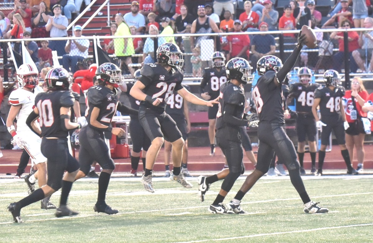 Mustang players celebrate after teammate Zach Warren (with ball) comes up with an interception during the Broncos' win against Yukon on Sept. 22, 2023. 