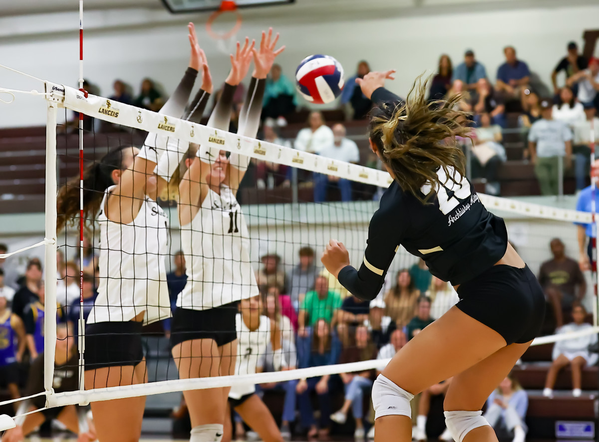 Isabella Romero (20) goes up for a kill against a tandem block from the Lancers. Photo: Jim Malone.