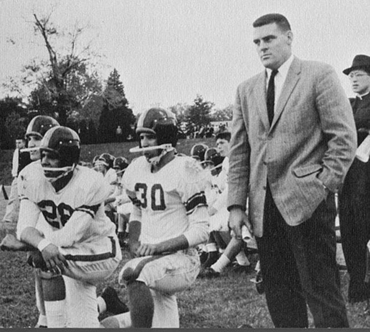 A young Joe Biden (30) crouches beside Archmere Academy football coach John Walsh in 1960.