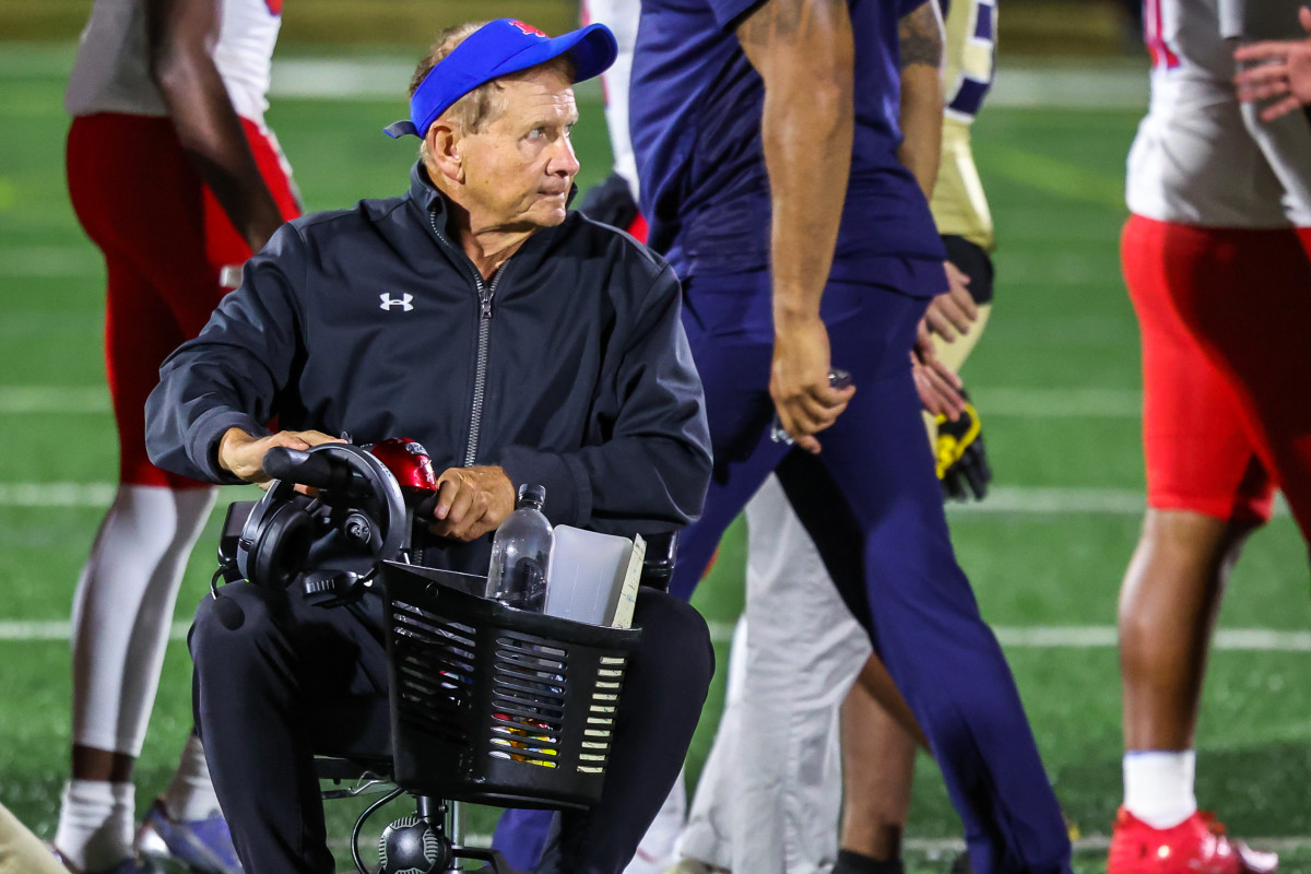 DeMatha football coach Bill McGregor leaves the field in a mobility scooter after talking to his team Friday evening. The longtime Stags coach will spend the rest of the season coaching in the scooter after suffering a fracture rib and pelvis in an accident last week.