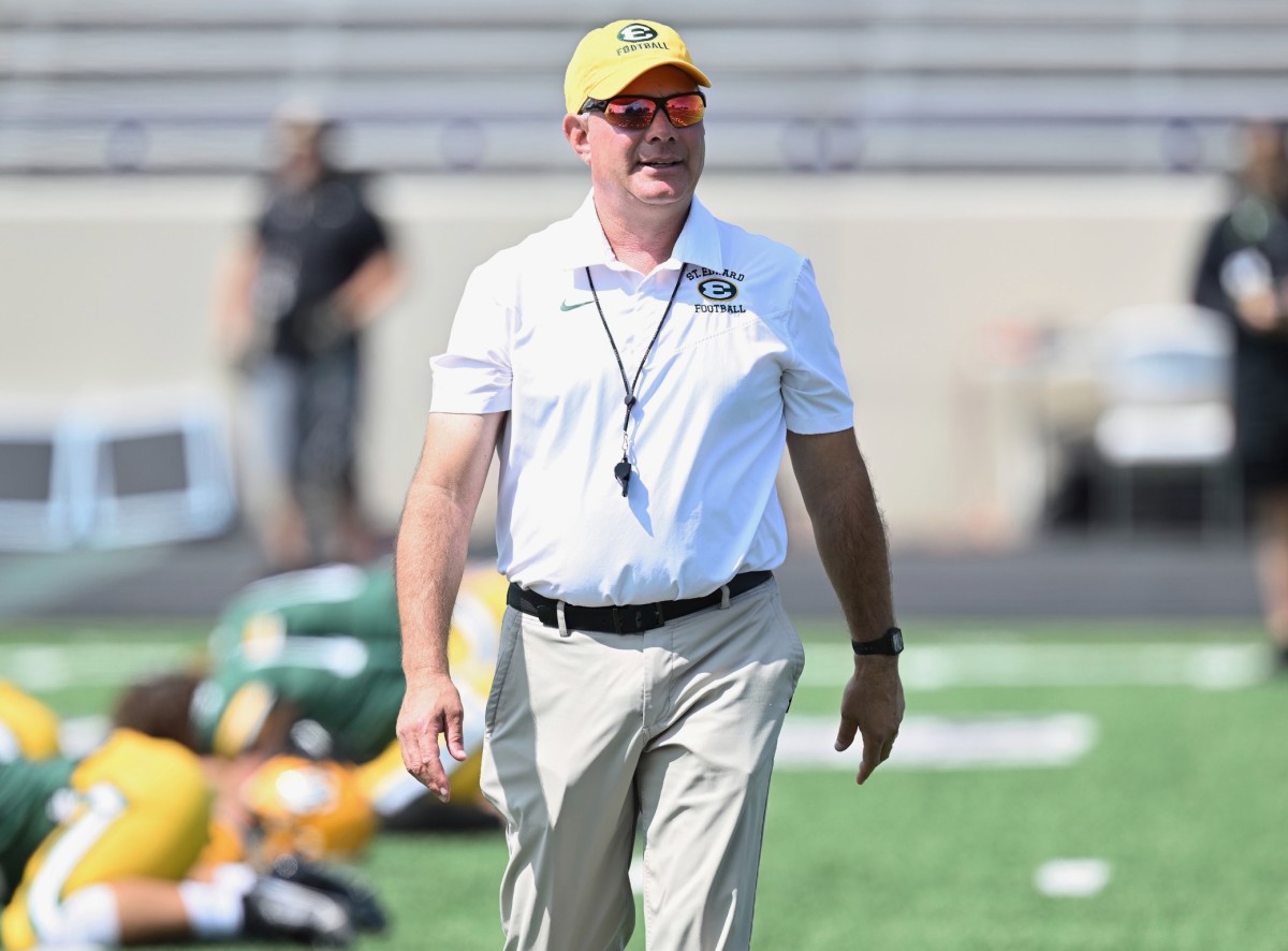 St. Edward football coach Tom Lombardo watches as his team warms up prior to a game. (Photo: Jeff Harwell)