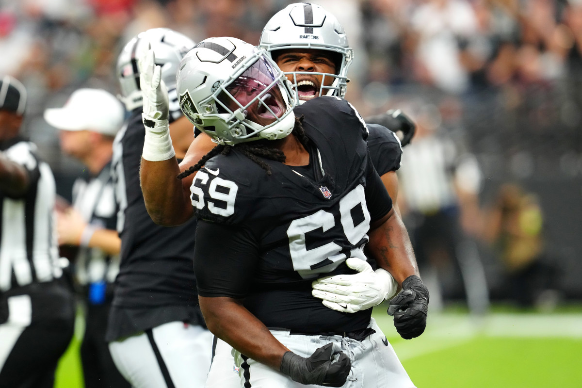 Las Vegas Raiders defensive tackle Adam Butler (69) celebrates with Las Vegas Raiders defensive tackle Jerry Tillery (90) after making a play against the New England Patriots during the first quarter at Allegiant Stadium.