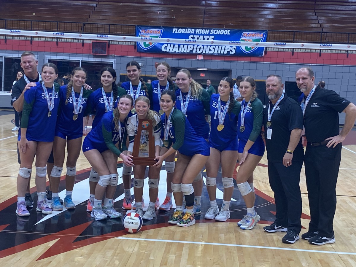 Seacrest Country Day players and coaches pose with their FHSAA Class 2A girls volleyball state championship trophy Tuesday at Polk State College in Winter Haven. It was their third consecutive title.
