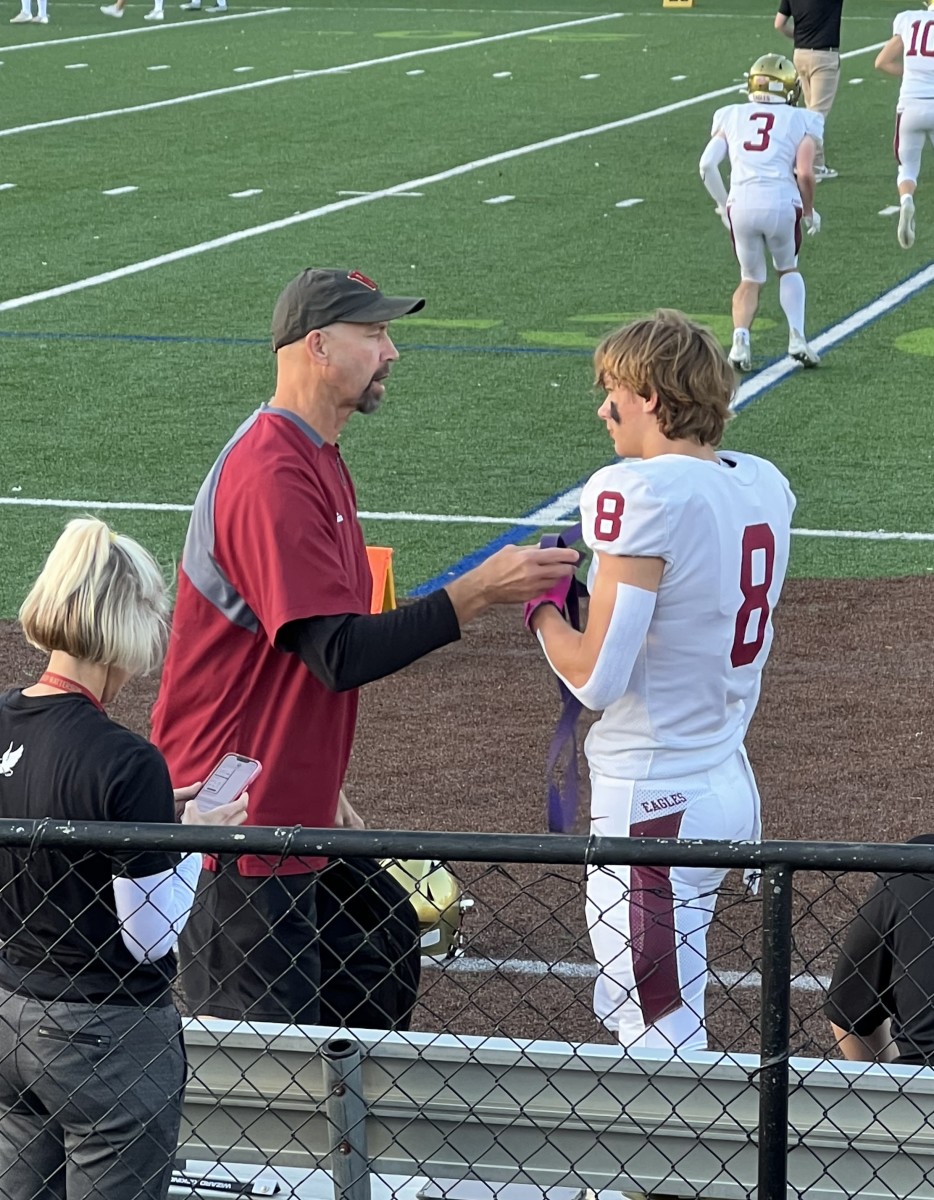 Jeff Uhlenahke coaches up his son, Jake, during a football game.