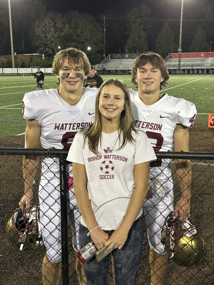 The three Uhlenhake kids - Allie (in front), Jake (No. 8) and Ben (No. 42) pose for a photo after a football game. 