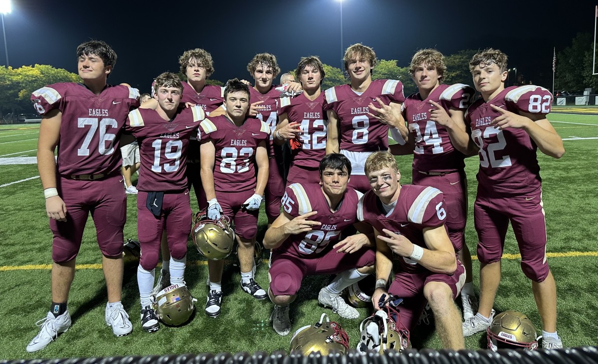 Jake Uhlenhake (No. 8) and Ben Uhlenhake (No. 42) pose with some of their teammates following a Bishop Watterson win.