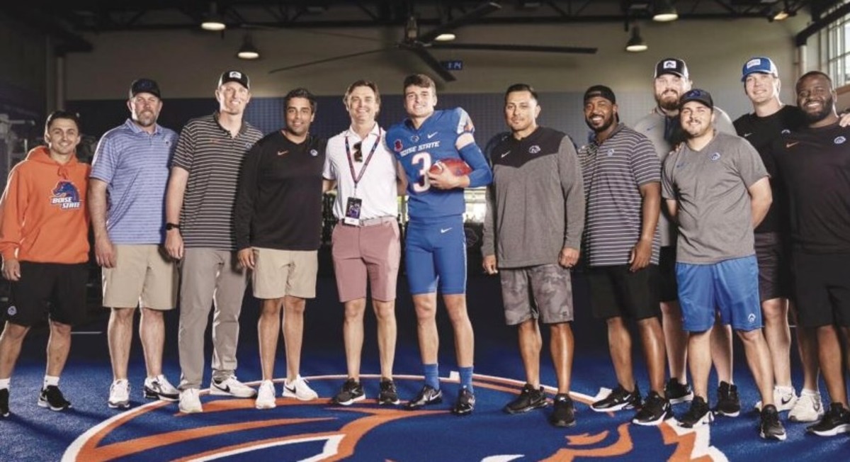 Kaleb poses with his dad Colby and the Boise State coaching staff during a visit.