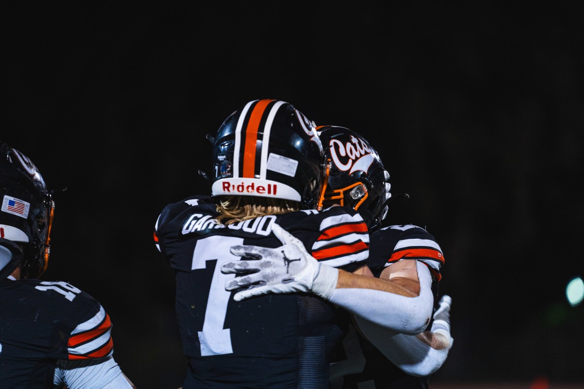 Scott Garwood (7) embraces with teammate earlier after big win playoff win over Riordan