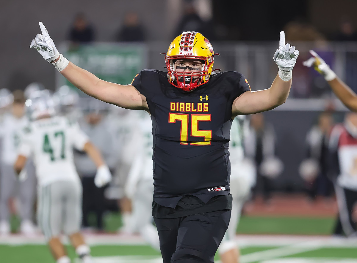 Mission Viejo 6-foot-6, 290-pound tackle Mark Schroller signaling his team's state Division 1-AA championship. 