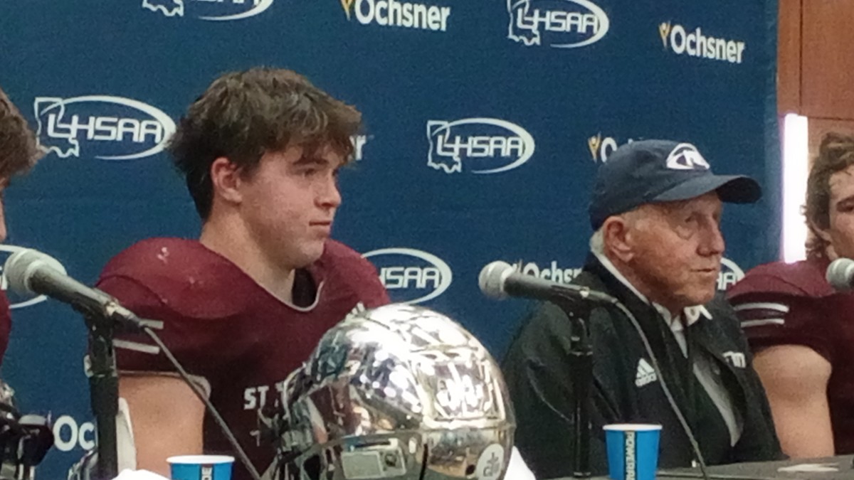 St. Thomas More linebacker Brody Latiolais (left) and coach Jim Hightower listen during a press conference following the Cougars' Division II select state championship win Dec. 9, 2023.