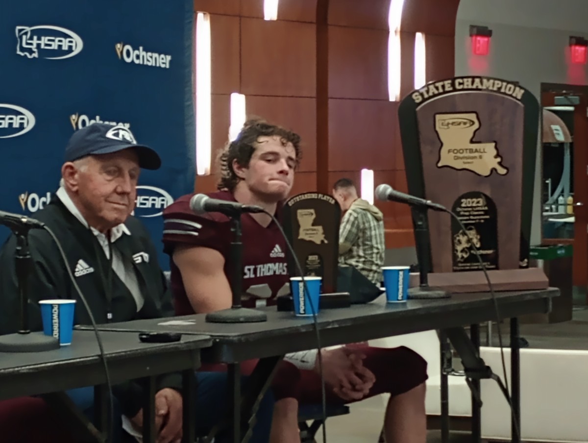 St. Thomas More coach Jim Hightower (left) and tailback John Luke St. Pierre listen to questions during a press conference following the Cougars' Division II select state title win Dec. 9, 2023.