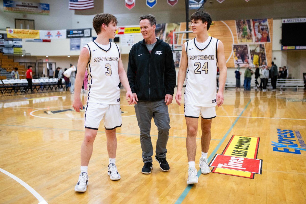 Kaden Groenig (left) walks off the court with his father, assistant coach Denny Groenig (center), and sophomore guard Drew Groenig, his younger brother, on Thursday night at the Les Schwab Invitational.