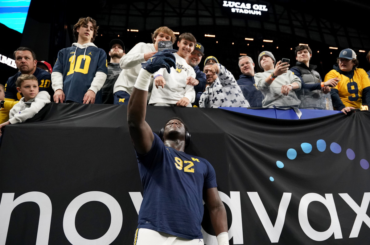 Dec 2, 2023; Indianapolis, IN, USA; Michigan Wolverines defensive lineman Ike Iwunnah (92) takes a selfie with fans before the Big Ten Championship game against the Iowa Hawkeyes at Lucas Oil Stadium. Mandatory Credit: Robert Goddin-USA TODAY Sports
