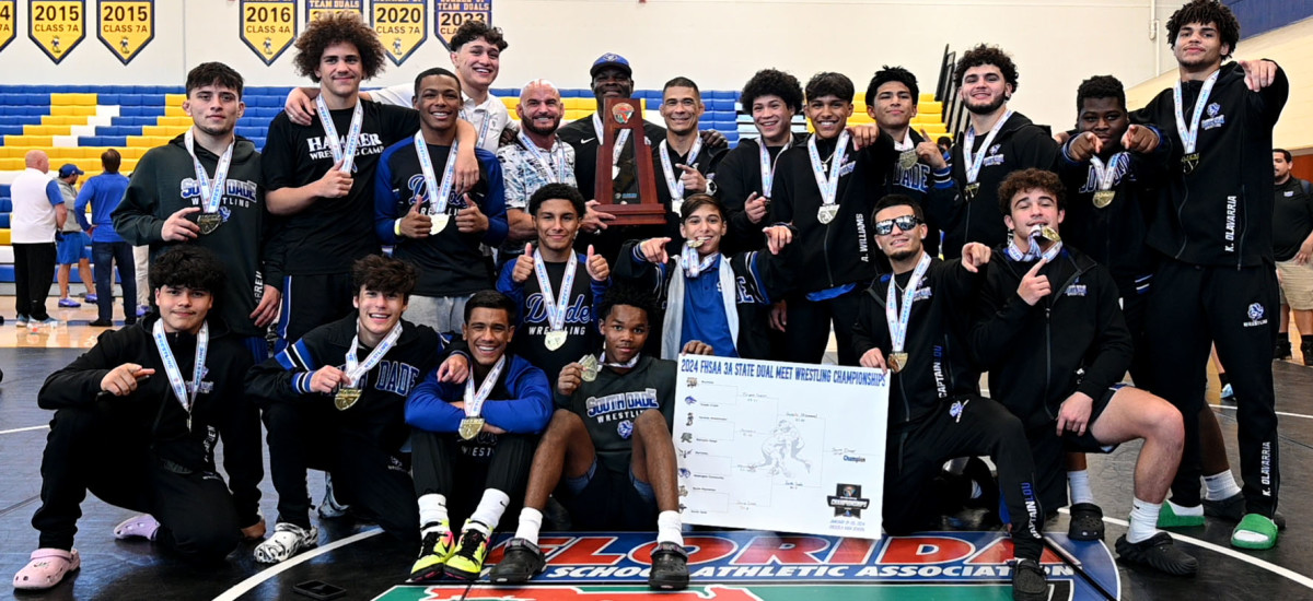 South Dade wrestlers and coaches gather with the FHSAA Class 3A Duals State Championship trophy on Saturday at the FHSAA Duals wrestling state championships at Osceola High School.