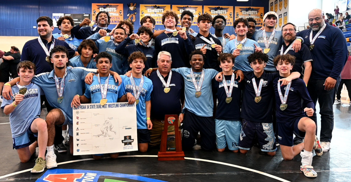 Somerset Academy wrestlers and coaches gather with the FHSAA Class 1A Duals State Championship trophy on Saturday at the FHSAA Duals wrestling state championships at Osceola High School