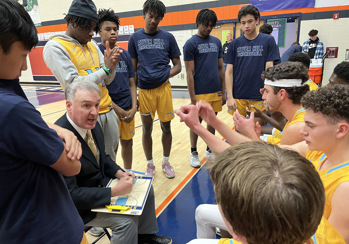 River Hill coach Matt Graves (sitting with clipboard) has switched gears this season, going from a slow, deliberate half-court attack to a high scoring, uptempo style. The Hawks have won 12 of their first 13 decisions.