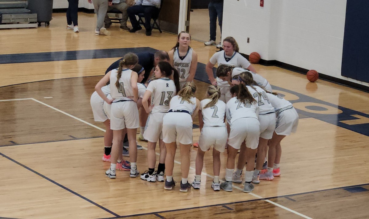 Rootstown players huddle around head coach Joe Leonard for final instructions prior to a game against Kirtland on January 29, 2024.
